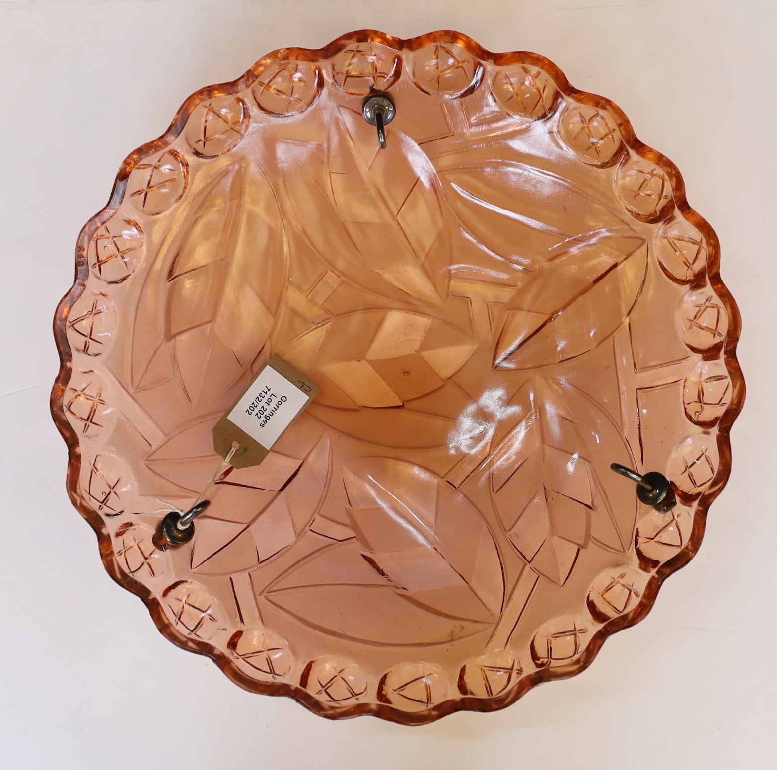 A 1930s French peach glass light bowl moulded with stylised leaves, with chain set and ceiling rose, diameter 39cm